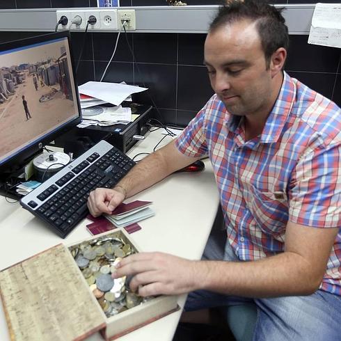 Jorge de la Iglesia muestra los pasaportes y las monedas coleccionadas en sus viajes. 