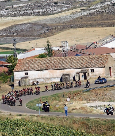 Los ciclistas dejan atrás la localidad de Valle de Cerrato, en la etapa celebrada ayer.