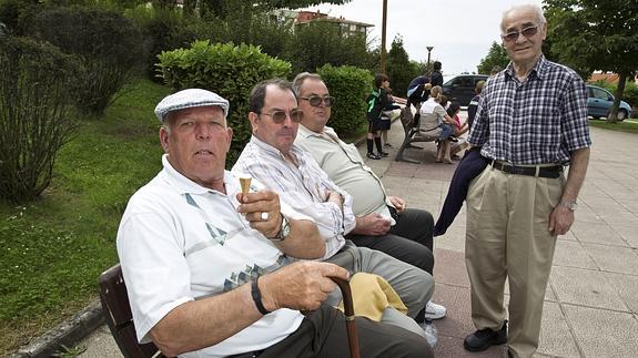 Un grupo de jubilados, en un banco en un parque.
