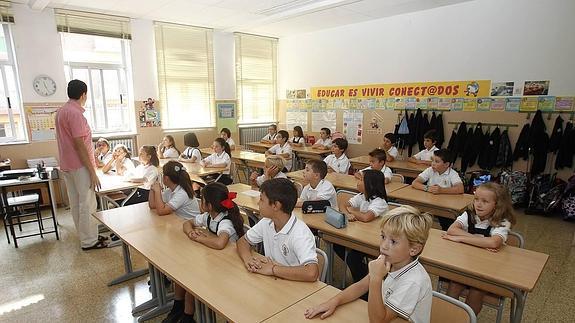 Alumnos atienden las explicaciones lor profesor, el primer día de clase.