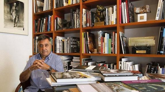 Gervasio Sánchez posa en su despacho frente a una mesa repleta de libros de Guerra.