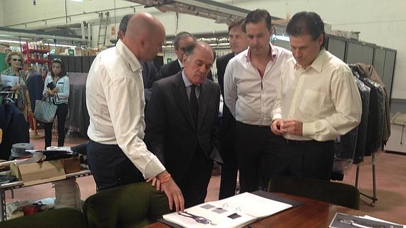 Los socios de Antonaga explican al consejero Tomás Villanueva el proceso de confección de un traje. 