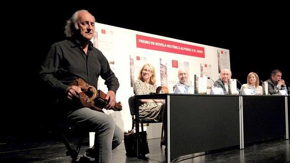 Amancio Prada interpreta un tema con la zanfona, ayer, en la presentación de la primera novela de Peridis.