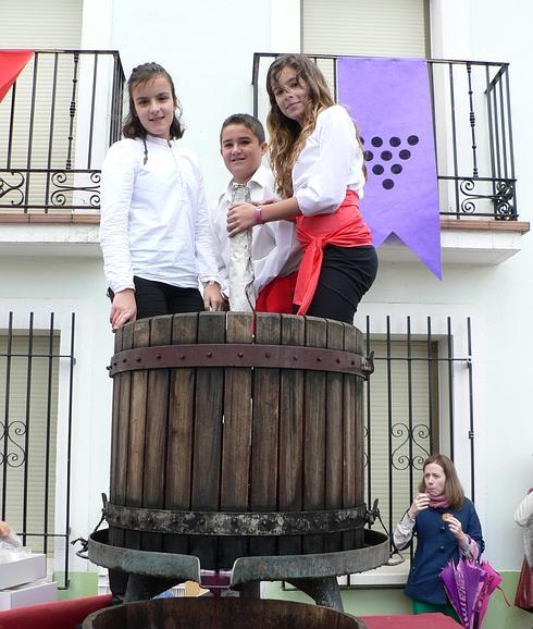 Isabel Villén, Gabriel Arranz y Gabriela Redondo, los pequeños lagareros durante la pisada de la uva de la Feria de la Vendimia de Quintanilla de Onésimo. 