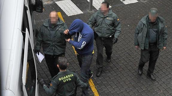 Uno de los detenidos sale de los juzgados de Medina y entra en el furgón.