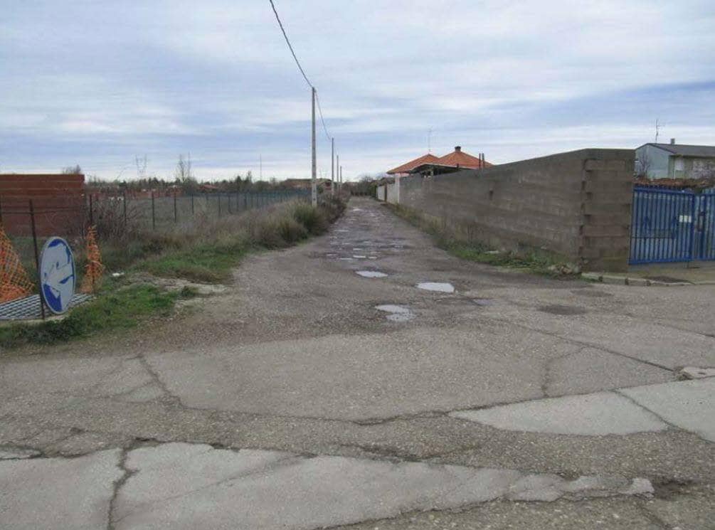 Acceso por un camino lleno de baches a una urbanización irregular en la provincia de Palencia.