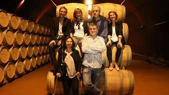 David y Fernando Trueba, junto a las bodegueras Yolanda y Carolina García Viadero, posan subidos sobre barricas; y el Gran Wyoming, junto a la productora Cristina Huete, esposa de Fernando.