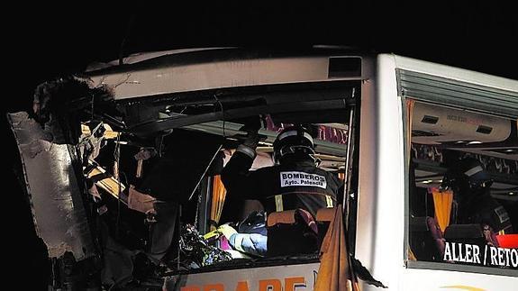 Un bombero trabaja en uno de los autobuses accidentados.