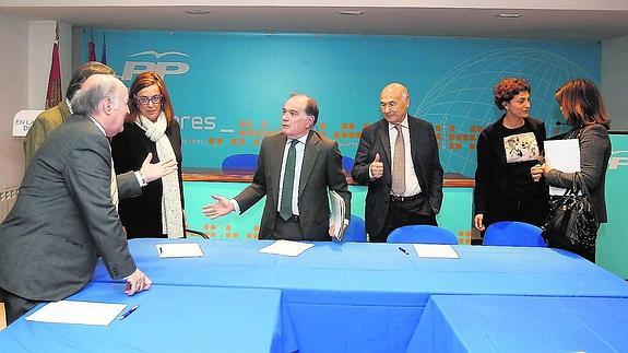 Tomás Villanueva, en el centro, dialoga con representantes del comercio, el turismo y la construcción, en la sede del PP. 