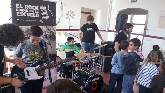 Los músicos de la banda Happening muestran los instrumentos a un agrupo de alumnos.