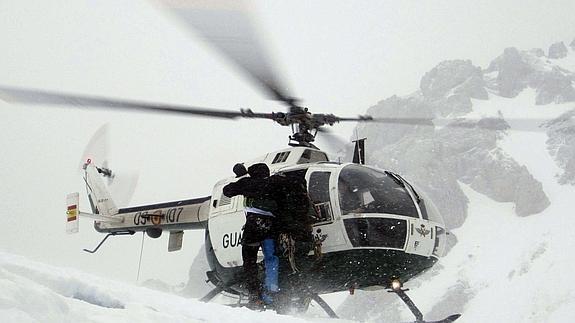 Miembros del Grupo de Rescate e Intervención en Montaña de la Guardia Civil rescatan en helicoptero a un montañero vizcaíno atrapado en el hielo en la Canalona, Picos de Europa, en marzo de 2013.