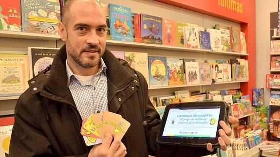Óliver Álvarez, con la baraja y la web del proyecto educativo.