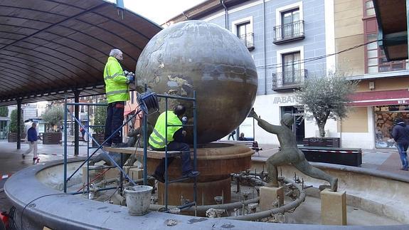 Los operarios pulen la Bola del mundo de la plaza de España. 