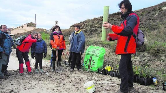David Arribas, a la derecha, de la asociación ARBA de Valladolid, explica cómo debe realizarse la plantación. 