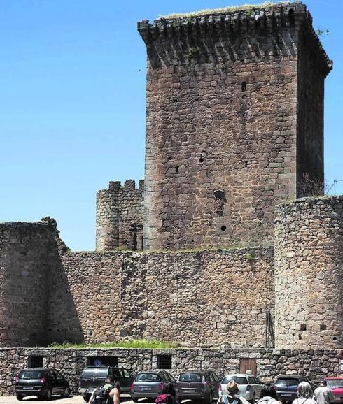 Un grupo de turistas pasea junto al castillo.