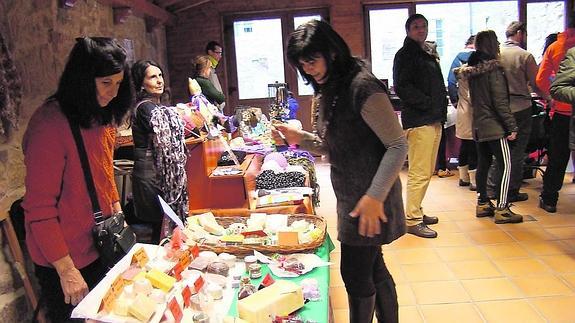 Una mujer observa jabones artesanos en los puestos de la feria celebrada el fin de semana en Aguilar.