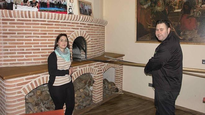 Rubi Espinosa y Fernando Díez, junto al horno de asar de su establecimiento en Pesquera. 