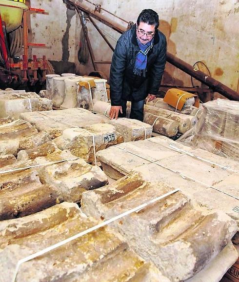 El alcalde, Celiano Vielba, muestra piedras auténticas de la antigua Iglesia almacenadas.