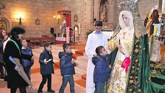 Varios pequeños participan en el besamanos de la Virgen de la Esperanza. 