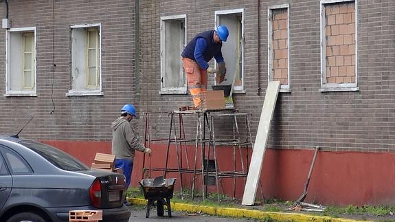 Los operarios tapian los huecos de las ventanas de los bajos en el patio del antiguo cuartel de Puente Colgante que da a al paseo del Cid. 