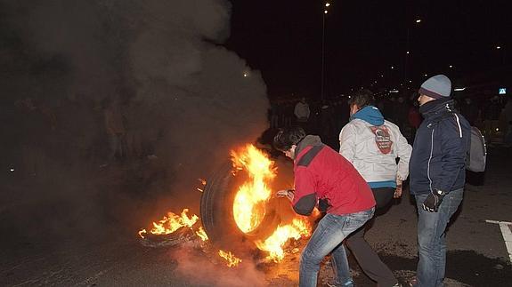 Varios trabajadores junto a las barricadas a la entrada de la planta de Nissan en Ávila.