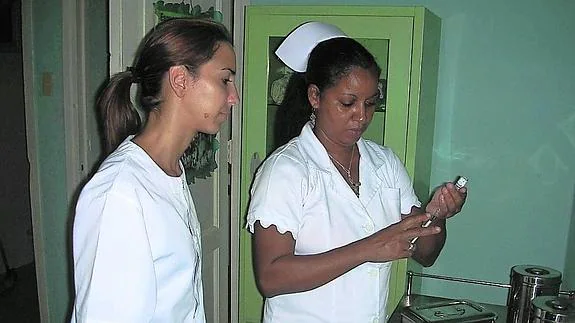 Isabel de la Rosa observa la preparación de una vacuna, en La Habana.