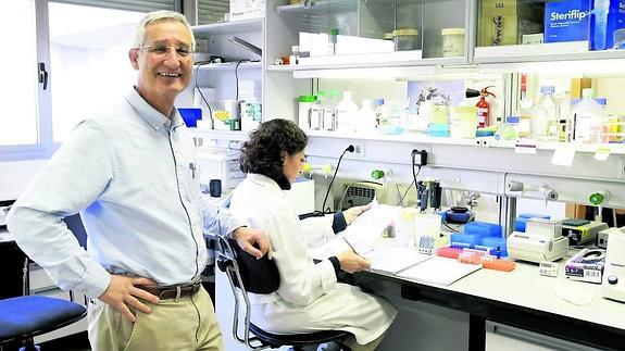 El director del Centro de Investigación de el Cáncer de Salamamanca, Eugenio Santos, con una de las investigadoras, en las instalaciones del centro.