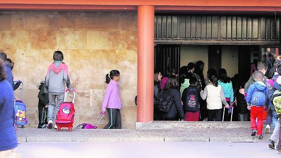 Escolares de Primaria acceden con sus mochilas al interior de su colegio para iniciar la jornada lectiva.