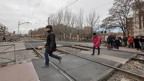 Un grupo de peatones en el paso del tren en Pilarica