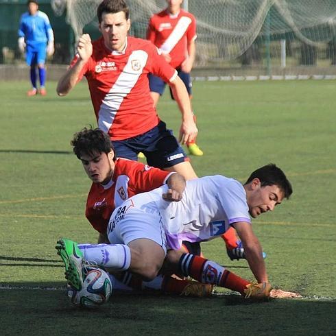 Alvarito disputa un balón con el goleador Claudio.