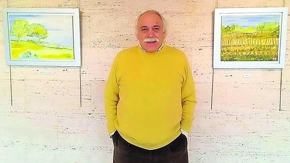 El pintor, entre dos de sus cuadros, en la sala Clara Campoamor de Baracaldo.