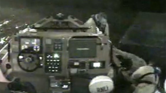 Los operarios del equipo de rescate sujetan cada uno por un brazo a uno de los españoles que cayeron al agua.