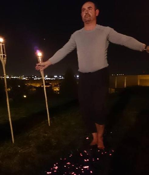 Un hombre realiza la técnica de 'Firewalking' durante un evento organizado por Esencia de Coaching en Arroyo de la Encomienda.