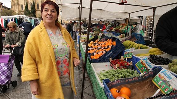 La alcaldesa posa junto a uno de los puestos de frutas y verduras en el mercadillo que todos los jueves se instala en la Plaza Mayor, junto a la Casa Consistorial. 