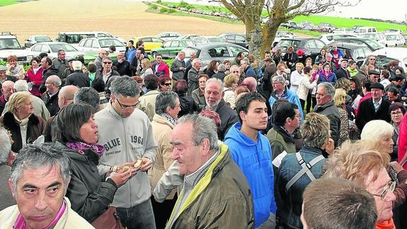 Algunos de los centenares de romeros que acudieron a la pradera de la ermita toman el pan y el queso.