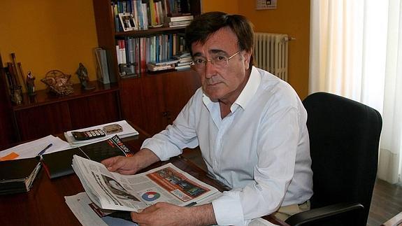 Jesús García hojea un periódico en su despacho.