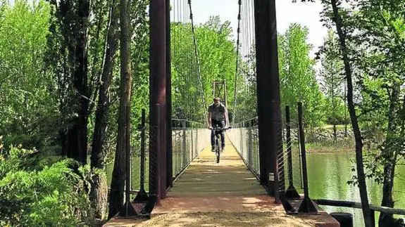 Un ciclista atraviesa la nueva pasarela en Herrera.