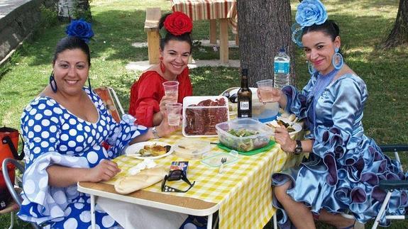 Unas jóvenes vestidas de flamencas en la paella de la feria. 