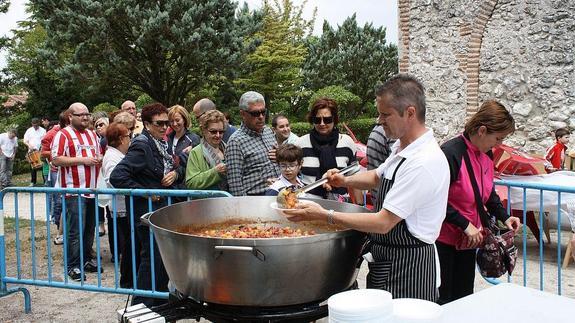 Los vecinos recogen sus raciones de caldereta en la Fiesta del Postiguillo.