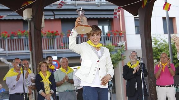 La exatleta Conchi Paredes alza el recuerdo que le entregó la Asociación de Vecinos de San Juanillo tras pronunciar el pregón. 