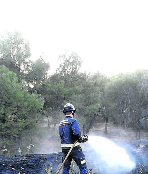 Un bombero apaga uno de los fuegos declarados