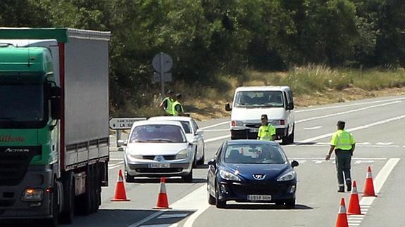 Guardias civiles controlan el tráfico en una carretera segoviana. 