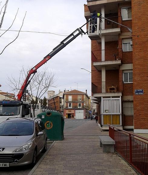 Operarios de la empresa Eufón trabajan en una farola de alumbrado público. 