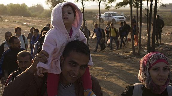 Refugiados cruzan la frontera entre Macedonia y Grecia. 