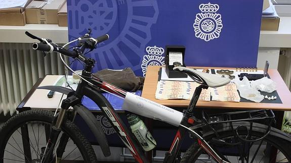 La bicicleta, el dinero y uno de los relojes intervenido por la Policia Nacional tras detener a J.R.G.G.