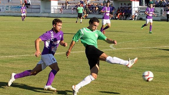 Melero dispara a portería contraria ante la presión del bañezano Íñigo, este domingo, en el campo de La Llanera. 