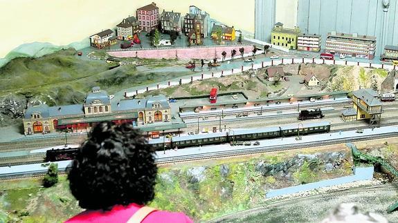 Una visitante observa una de las grandes maquetas que se reúnen en la exposición ferroviaria.