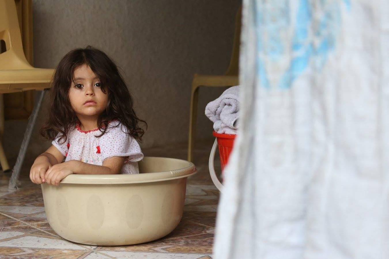 Una niña, en un balde en su tienda del campo de refugiados de Solimanía. FOTO CEDIDA POR PABLO SANTANA