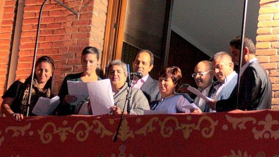 La junta de empresarios, comerciantes y hosteleros de Nava lee el pregón desde el balcón del Ayuntamiento. 