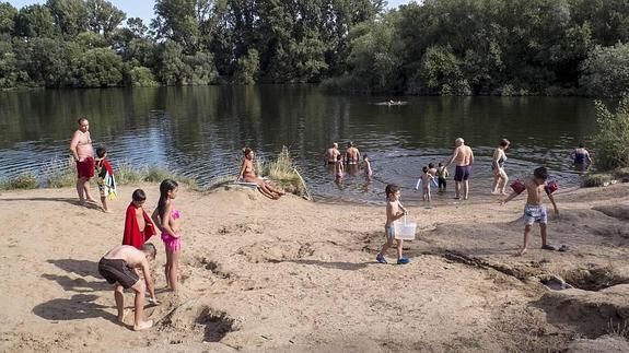 Las altas temperaturas animan a refrescarse en el río Tormes.